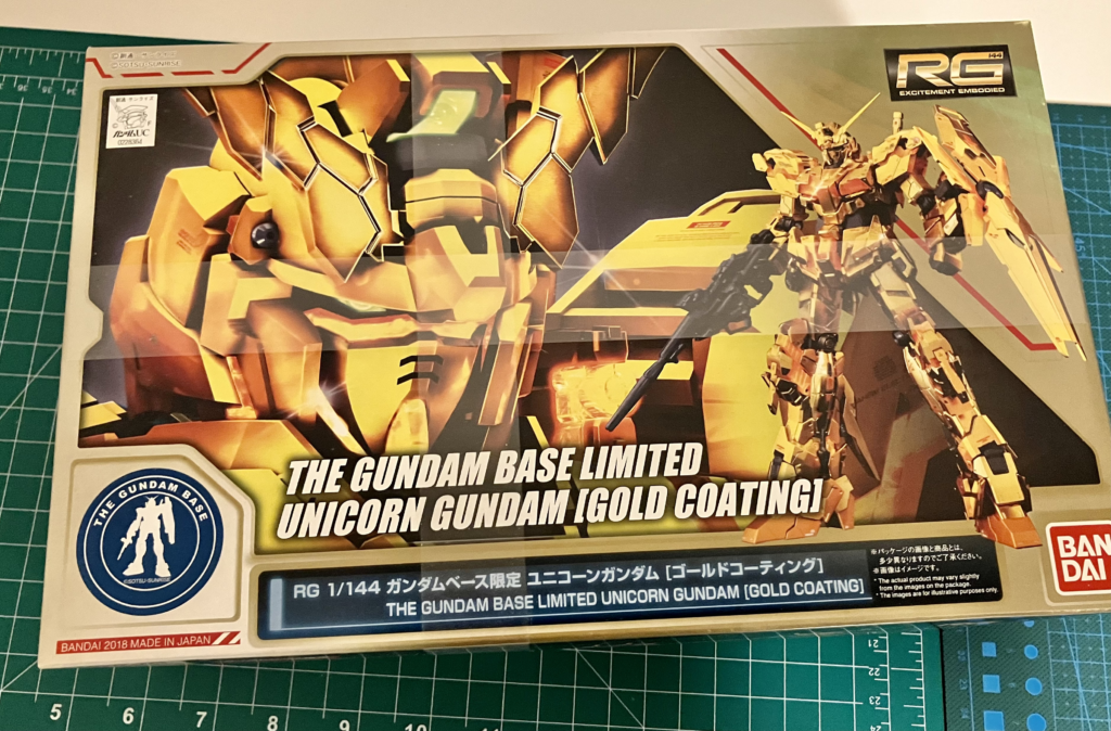 A Real Grade Gundam Base Limited Unicorn Gundam (Gold Coating). To the uninitiated, that just looks like a random string of words, but in simple terms this is the box for a model robot kit. More specifically, a piloted mechanical vehicle called a “Gundam” that looks like a big robot. Ban Dai makes these model kits, which are considered high quality, fully-articulated representations of these Gundam portrayed in various anime series. This one in particular is a limited edition variant with gold coating, so it’ll look cool. Which is why I bought it